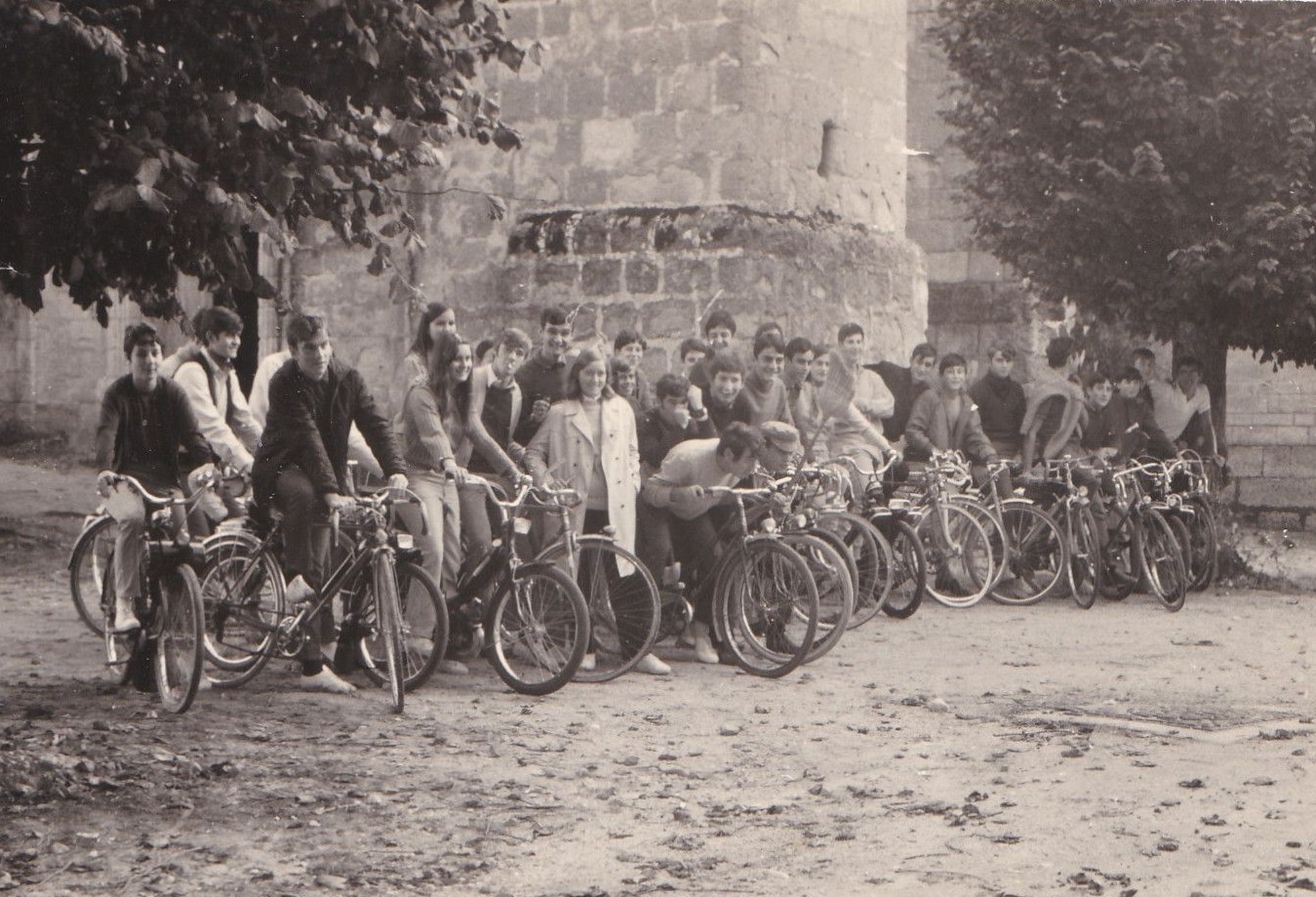 La jeunesse en selle — Juillet 1970. Rassemblés sur la place de l'église avant le départ d'un rallye à vélo, ces jeunes du village posent dans une joyeuse atmosphère de camaraderie. Une scène simple et attachante qui évoque les loisirs d'une génération et la vie locale d'autrefois.